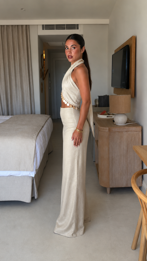 Side view of cream halter wide-leg jumpsuit with draped bodice